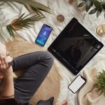 personne devant un écran et deux téléphones